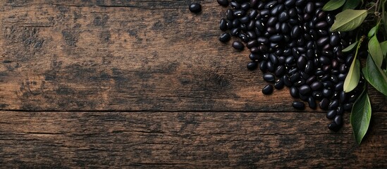 Canvas Print - Black Beans in Natural Setting on Rustic Wooden Table with Green Leaves and Space for Healthy Food Text Decoration