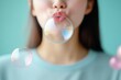 © Sergio - Girl blowing soap bubbles in a colorful and playful setting with a light blue background