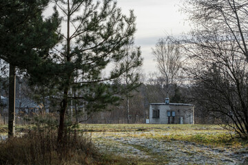 round building made of white bricks in meadow. Dry grass, fence around