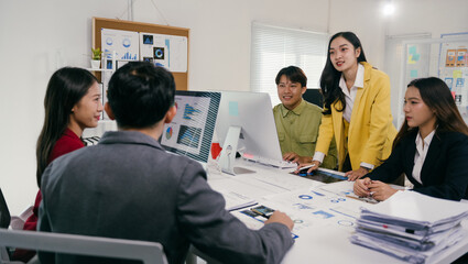 Aufkleber - Group of young asian businesspeople working and discussing using computer and documents showing graphs and charts in a meeting room at the office