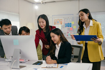 Poster - diverse asian businesspeople collaborating on a project, analyzing data displayed on a computer scre