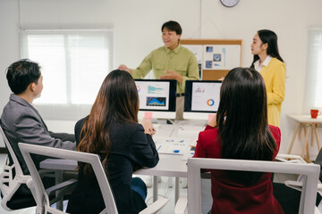 Fototapete - Group of professional businesspeople listening to their manager explaining a new strategy for their company using data charts on a computer screen