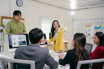 Sticker - Group of young asian businesspeople discussing and brainstorming analyzing financial graph company statistics and pointing on computer screen in a meeting