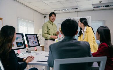Poster - Group of young asian businesspeople discussing charts and graphs showing company's growth and analyzing financial stats sitting at the table in the modern office