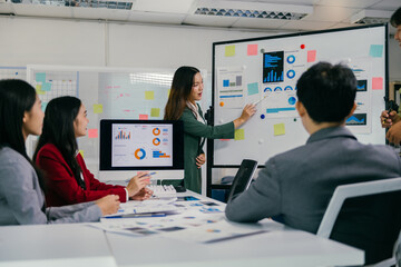 Aufkleber - During a business meeting, an asian businesswoman explaining statistics and data analysis with charts and graphs, promoting collaboration and strategic decision-making
