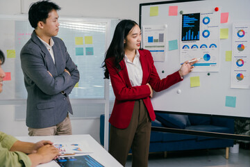 Fototapete - During a business meeting, a businesswoman uses a whiteboard with charts and graphs to explain statistics and data analysis to her colleagues, fostering collaboration and strategic decision-making