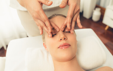 closeup woman enjoying relaxing anti-stress head massage and pampering facial beauty skin recreation