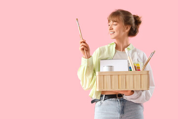 Wall Mural - Female artist with art supplies on pink background