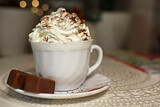 filiżanka czekolady z bitą śmietaną, biała filiżanka kawy z bitą śmietaną, a cup of chocolate with whipped cream, a white cup of coffee with whipped cream, hot chocolate topped with whipped cream