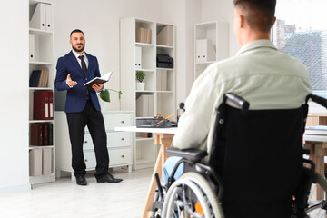 Wall Mural - Male lawyer with book and client in wheelchair at office