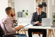 © Pixel-Shot - Young lawyer working with man in wheelchair at office