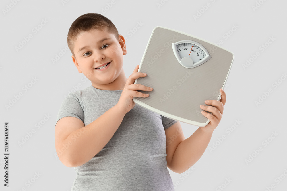Overweight boy with weight scales on light background. Diet concept