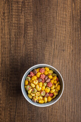 Canvas Print - Colorful breakfast cereals in the shape of various fruit in bowl on wooden table. Top view.