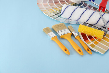 Poster - Different painter's tools on light blue table, space for text. Decorating and design