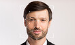 © Prostock-studio - A man with a neutral expression stands against a plain background, displaying facial recognition technology that detects his facial features for identification purposes.