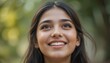 © AKSNA - Close Up Portrait of a Young Indian Woman in Professional Suit with Radiant Smile and Warm Expression on Light Blue Background
