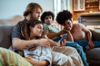 © Davor - Group of friends relaxing on couch using smartphones