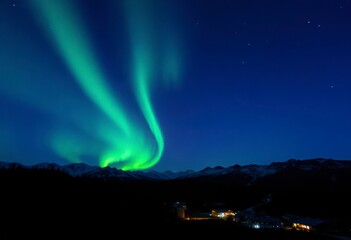 vibrant northern lights grace the night sky above majestic mountains, creating a magical atmosphere 