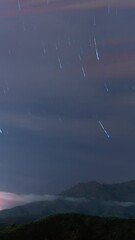 Wall Mural - Star trails and moving clouds, vertical time lapse