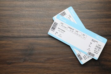 Sticker - Travel agency. Flight tickets on wooden table, top view. Space for text