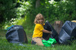 © Volodymyr - Child collecting trash outside. Ecology concept. Environmental pollution. Earth Day. Recycle waste litter rubbish garbage trash junk clean. Nature cleaning. Environment plastic pollution.