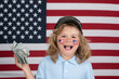 © Volodymyr - American money. Kid with hundred dollars money isolated on studio background. American little patriot. Independence day 4th of july. Child with american flag. American flag on kids cheek.