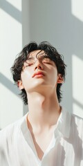 Aufkleber - Sunlit Mindfulness Young Asian Man in Relaxed Pose Embracing Minimalist Wellness Trend - Mental Health Marketing and Tranquil Office Spaces