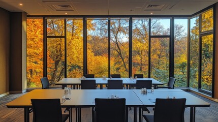 Poster - Conference room set up for sessions, large windows offering a serene view of autumn trees, creating a peaceful and inspiring atmosphere