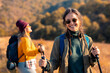 © Zoran Zeremski - Portrait of smiling woman hiking with her friend at top of the hill at meadow looking at camera..