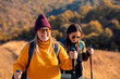 © Zoran Zeremski - Two smiling woman hiking at top of the hill at meadow.