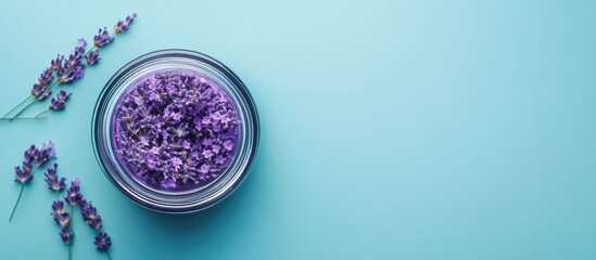 Poster - Lavender flowers in a glass jar on a turquoise background with copy space for text or graphics.