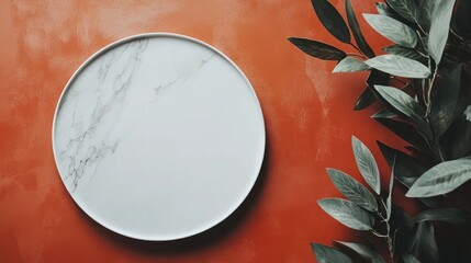 Aufkleber - Promotional flat lay of a white marble plate surrounded by green leaves on an orange textured background, ideal for marketing and advertising concepts.
