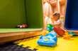 © Mariakray - Young child enjoying educational playtime with colorful activity toys in a safe and modern playroom