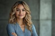 © Roby - A smiling woman with wavy hair poses confidently against a neutral background.