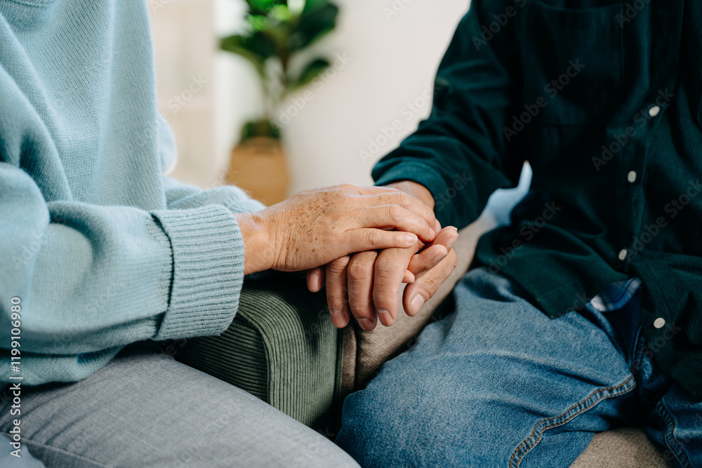Hands of the old man and a woman hand on the table