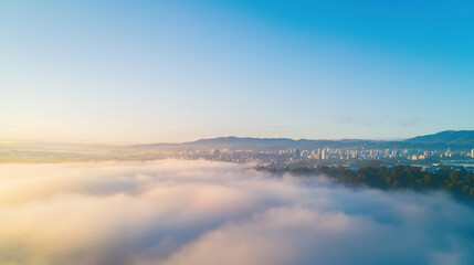 Poster - Aerial view of city skyline emerging from fog under clear blue sky