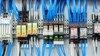 Poster - A bunch of wires are connected to a device. The wires are blue and white. The device is a computer