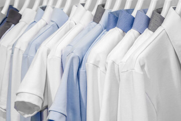 Poster - A row of white and blue shirts hanging on a clothesline. The blue shirt is the only one with a pattern
