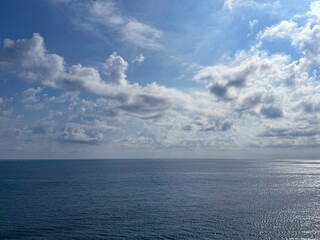 Wall Mural - wide blue ocean and fluffy clouds in blue sky