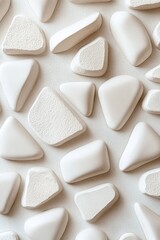 Poster - Geometric ceramic shapes in soft white and beige are arranged on a clean neutral surface. This modern abstract design creates a calming atmosphere with ample space for text overlay