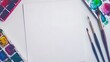 © Jittra - A minimalistic art station showcasing a watercolor palette, brushes, and blank paper ready for painting on a clean table
