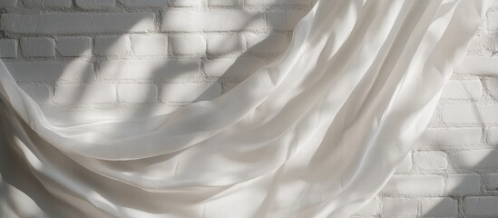 Poster - Serene flowing white fabric draped against textured white brick wall casting soft shadows, creating a tranquil ambiance with ample copy space.