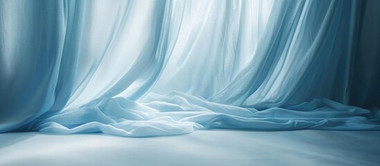 Poster - Flowing soft blue fabric draping elegantly across a smooth surface in a serene setting with ample copy space for text and visual appeal.