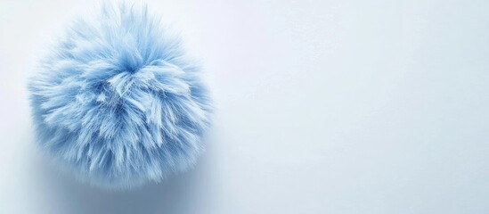 Poster - soft blue fluffy pom pom elegantly placed on a pristine white background with ample negative space f