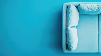 Poster - Top view close up of cozy soft blue sofa cushions on bright turquoise background with ample empty space for design or text elements.