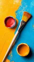 Poster - A lively arrangement captures a paintbrush alongside vibrant containers of red and yellow paint on a blue and yellow background, inviting imagination and artistic expression