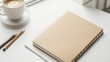 © acnaleksy - simple, customizable notebook cover mockup, lying flat, on a clean white surface with a pencil and a cup of coffee nearby