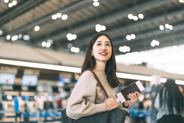 Wall Mural - Woman passenger holding passport and boarding pass to transit at international airport terminal for depature with airline transport