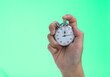 © xy - People hand holding stopwatch on green background