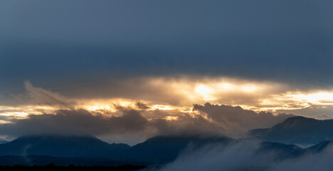 Wall Mural - the sun rises from the mountainside